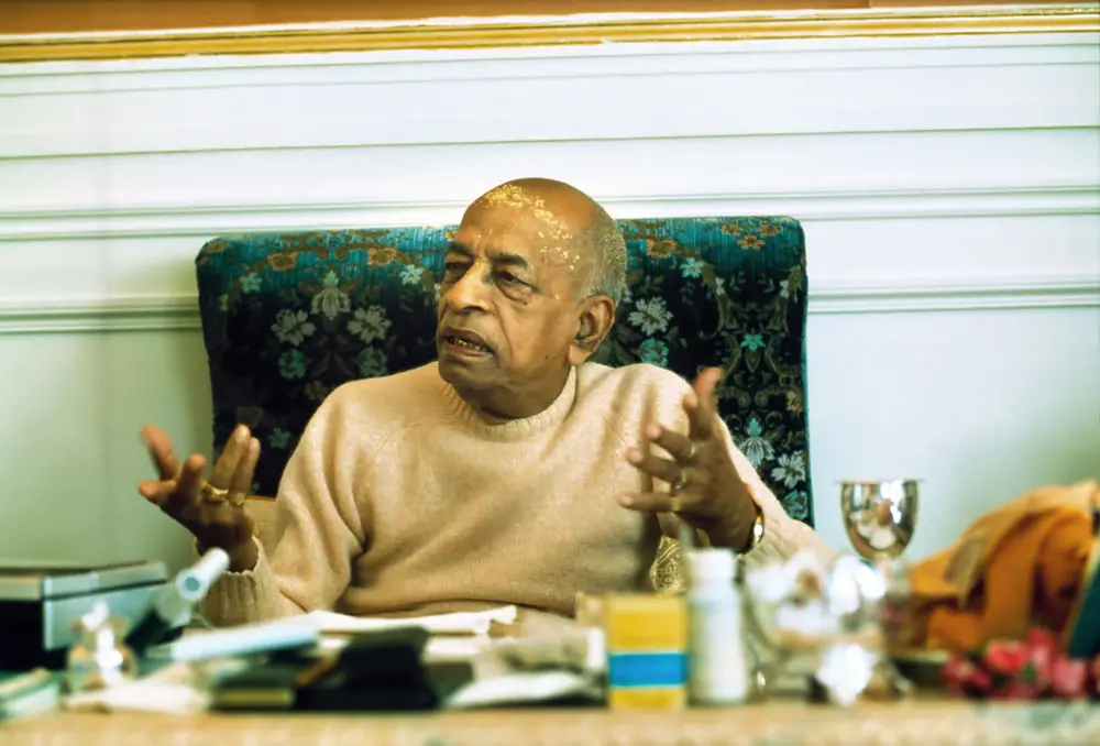 Prabhupada Sitting at Desk Explaining Philosophy to Guests